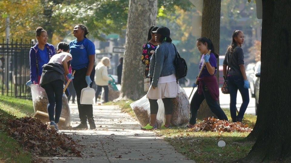 Students from New Hope Academy cleaning with their teacher.