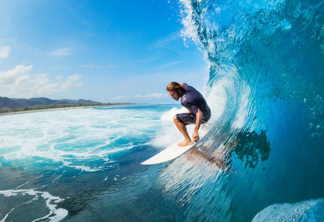 Surfer on Blue Ocean Wave in the Tube Getting Barreled